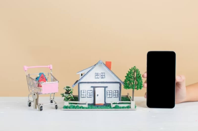 model of house and a hand hold smart phone