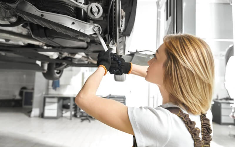 woman repairing in a car