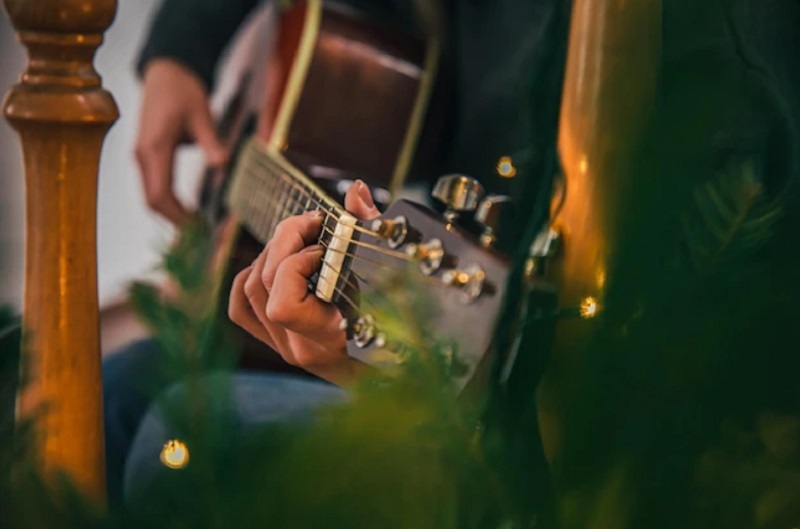 man hand holding guitars