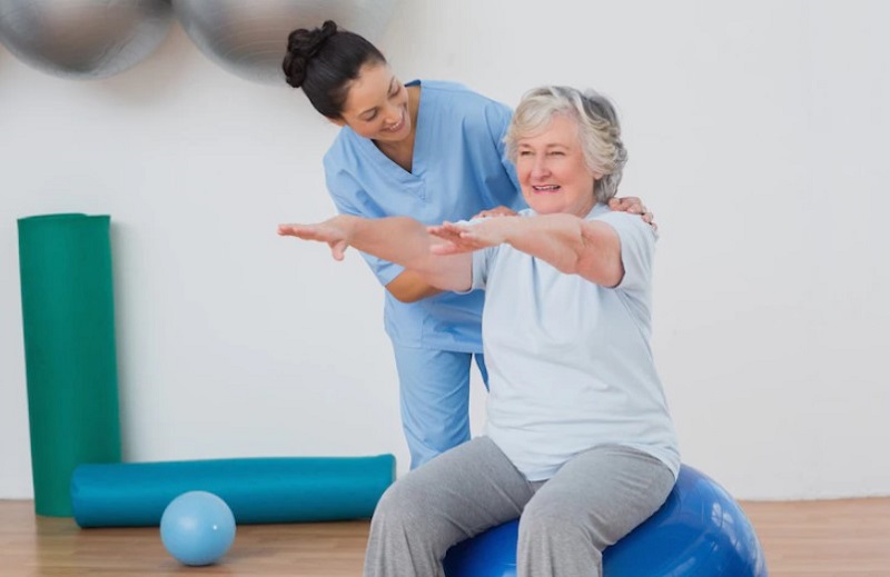 physiotherapist-assits-senior-woman-in-exercising