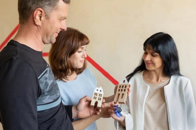 saler-hand-holding-key-and-customer-hand-holding-wood-house