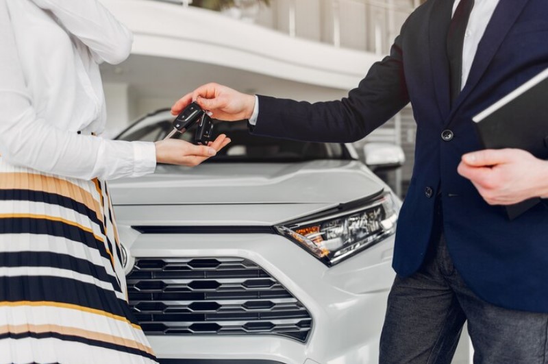 Dealer hand holding car rental agreement