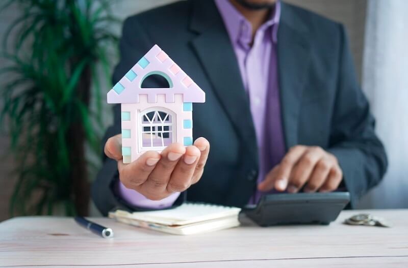 person holding a toy house